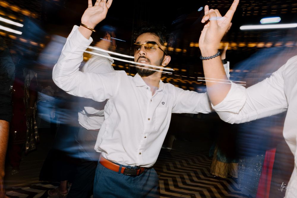 Energetic dance floor moments captured during a wedding reception with dynamic lighting.