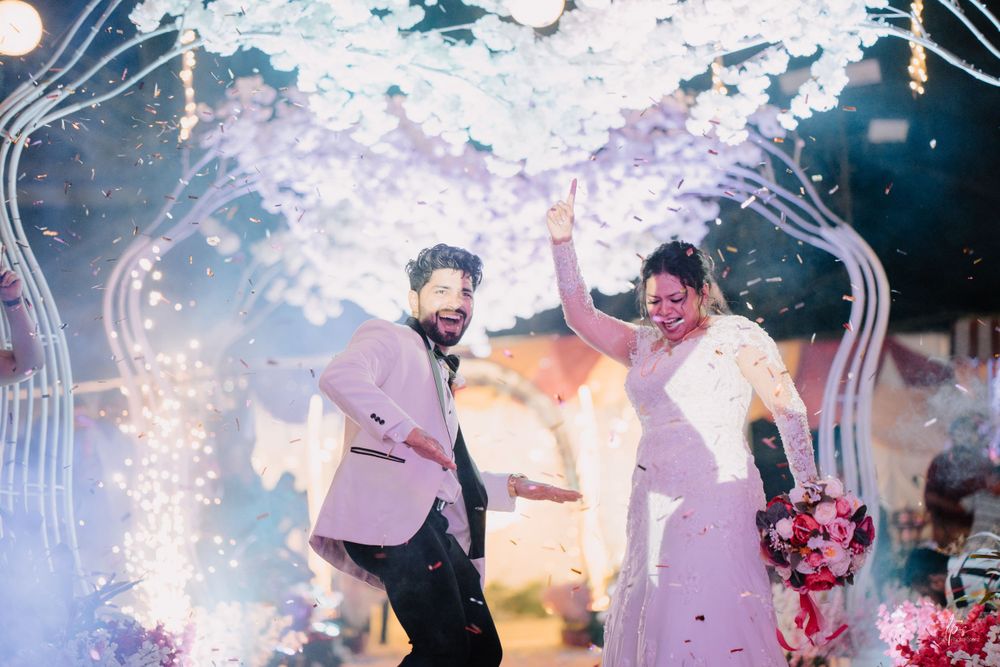 Wedding celebration with couple dancing under sparklers and white floral decorations.