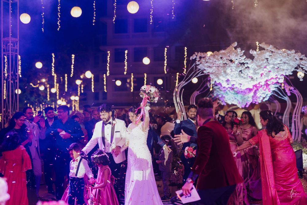 Wedding celebration with colorful lighting and guests dancing on the dance floor.