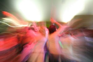 Abstract motion blur photograph with red and white light streaks creating dynamic patterns.