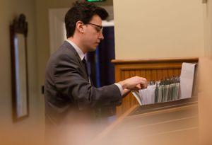 Student searches through file cabinet in administrative office.