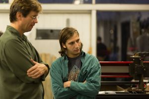 Two filmmakers collaborate while reviewing footage on professional camera equipment.