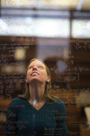 A sequence of photos showing someone laughing and looking up while sitting in a classroom setting.