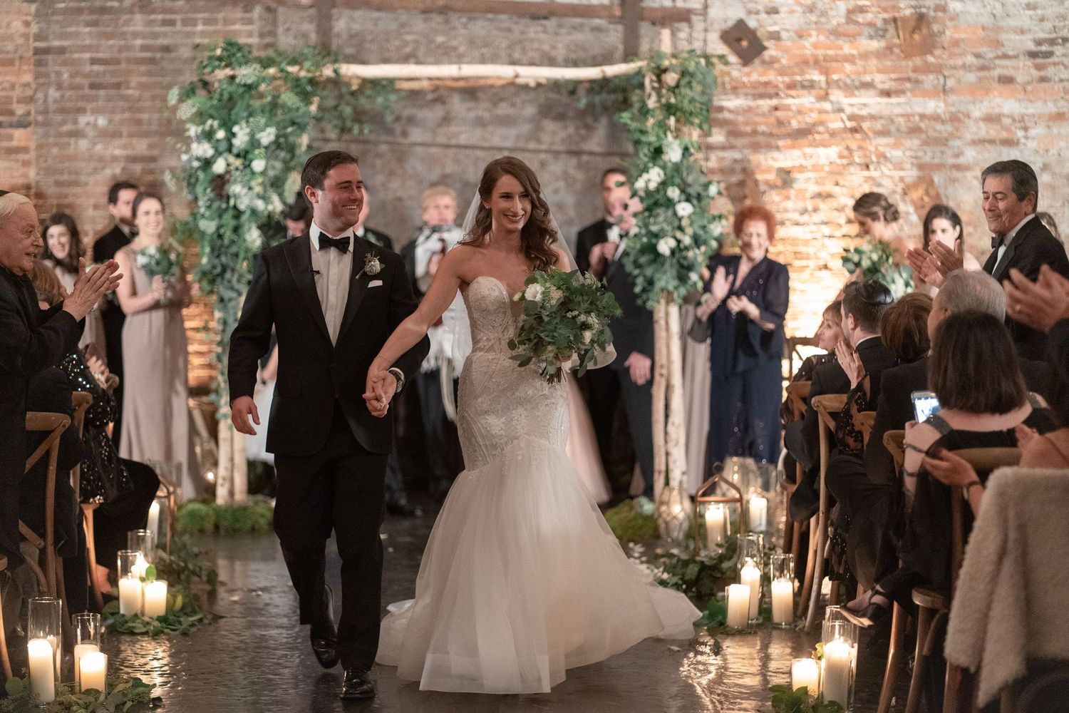 Bride and groom have rustic industrial Jewish winter wedding with floral chuppah at King Plow Arts Center