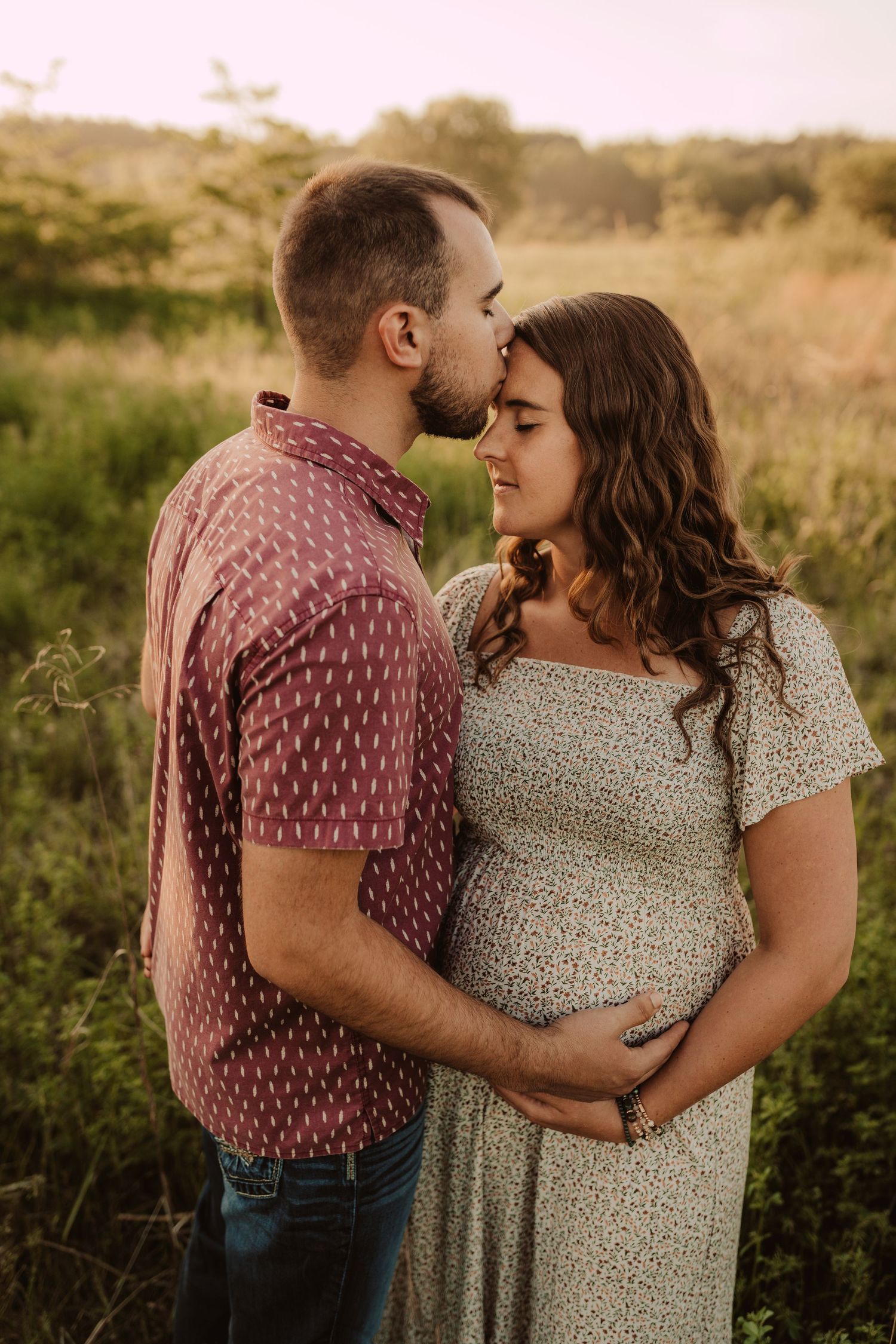 sweet kisses in the field for maternity photography session