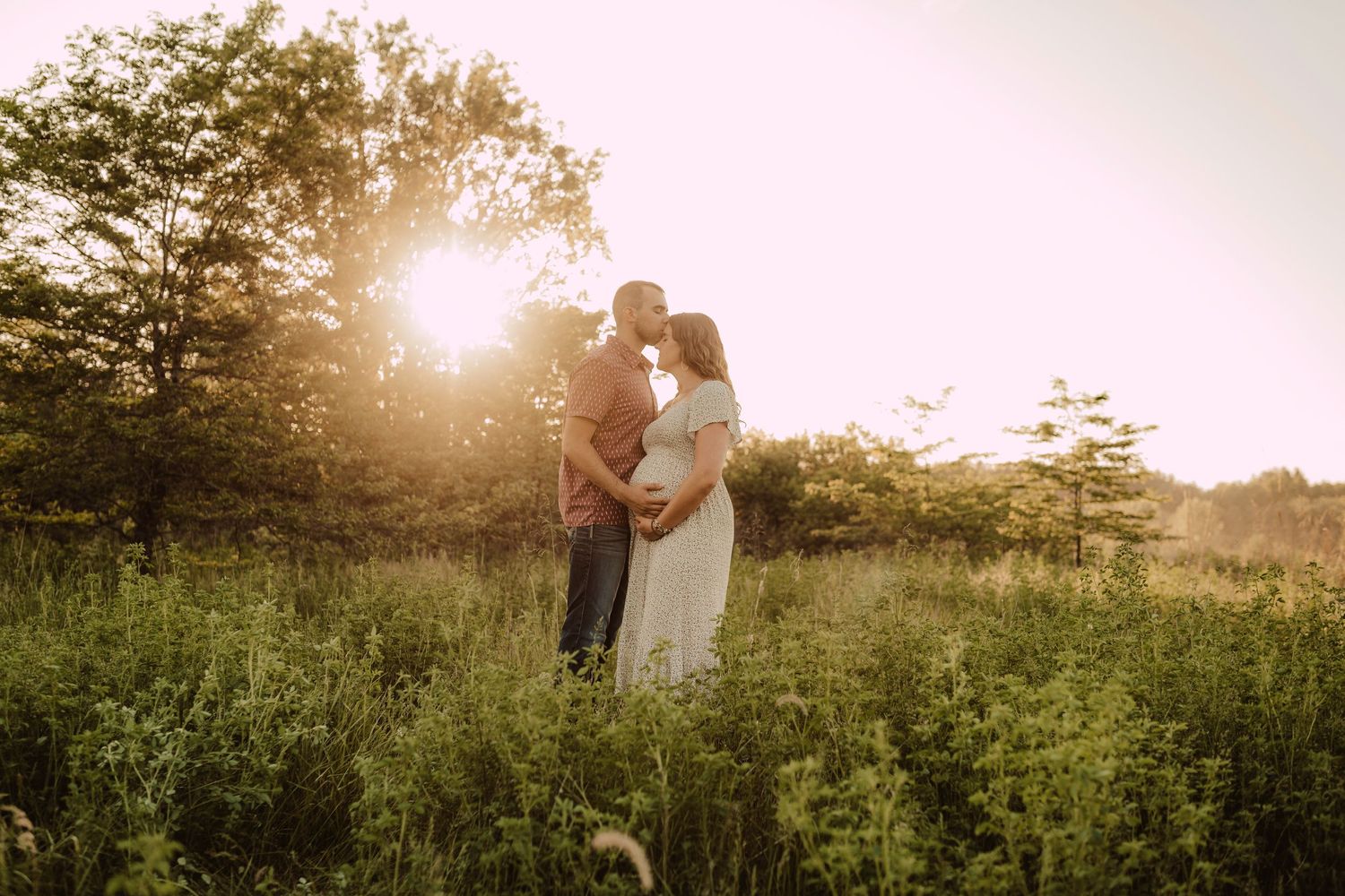 sweet kisses in the field for maternity photography session