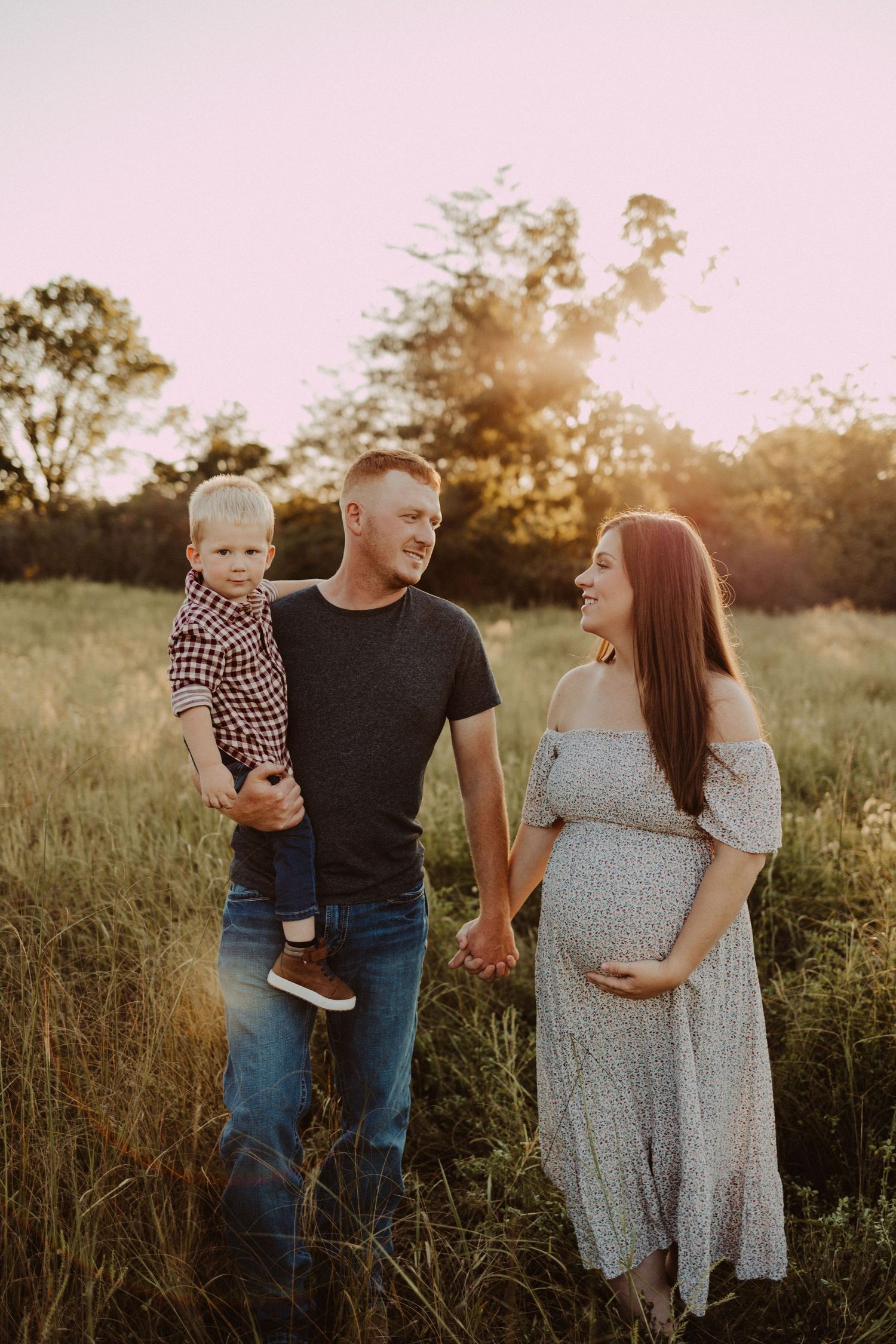 walking in the field family of three maternity session