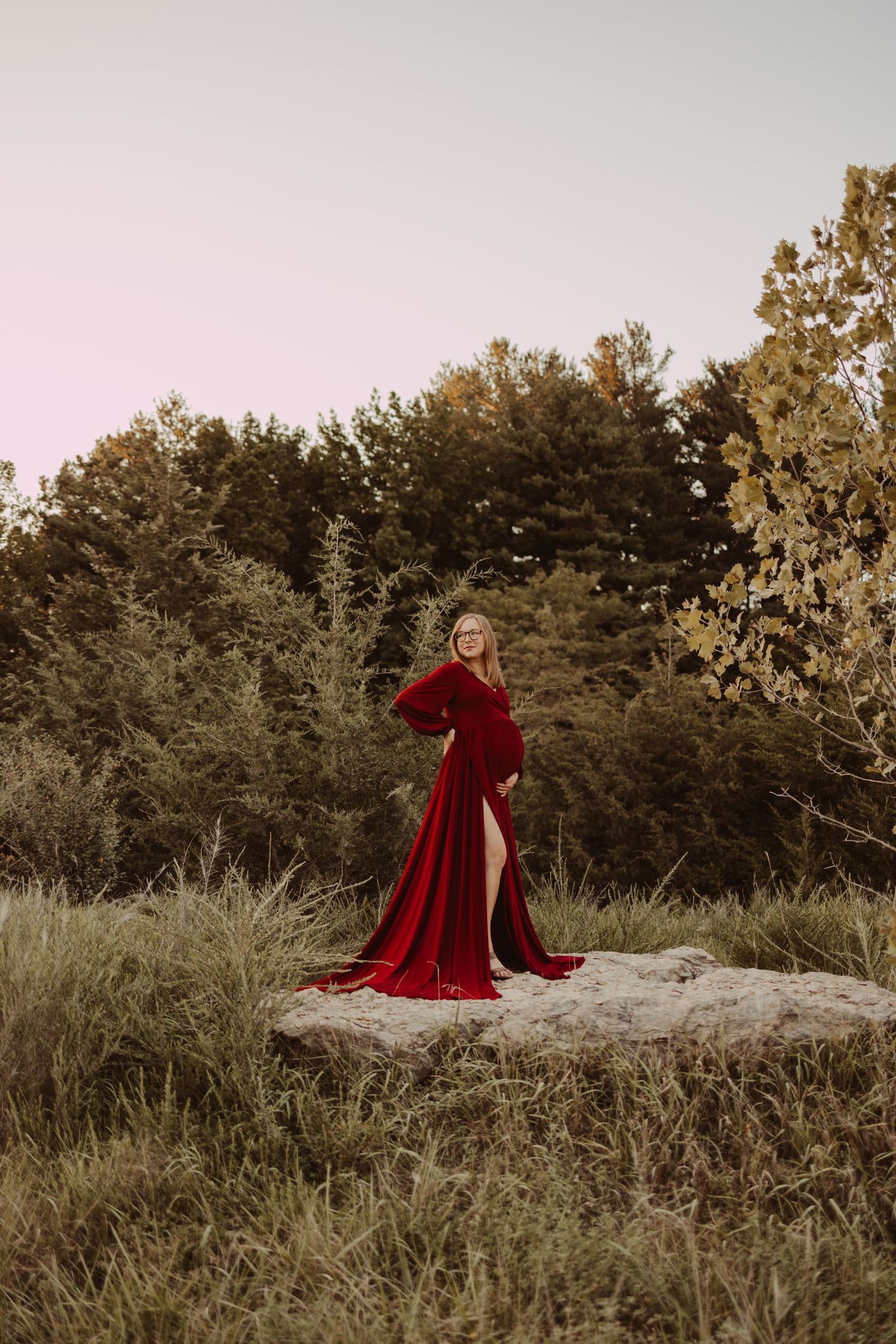 beautiful maternity session with mom posed on a rock in a field