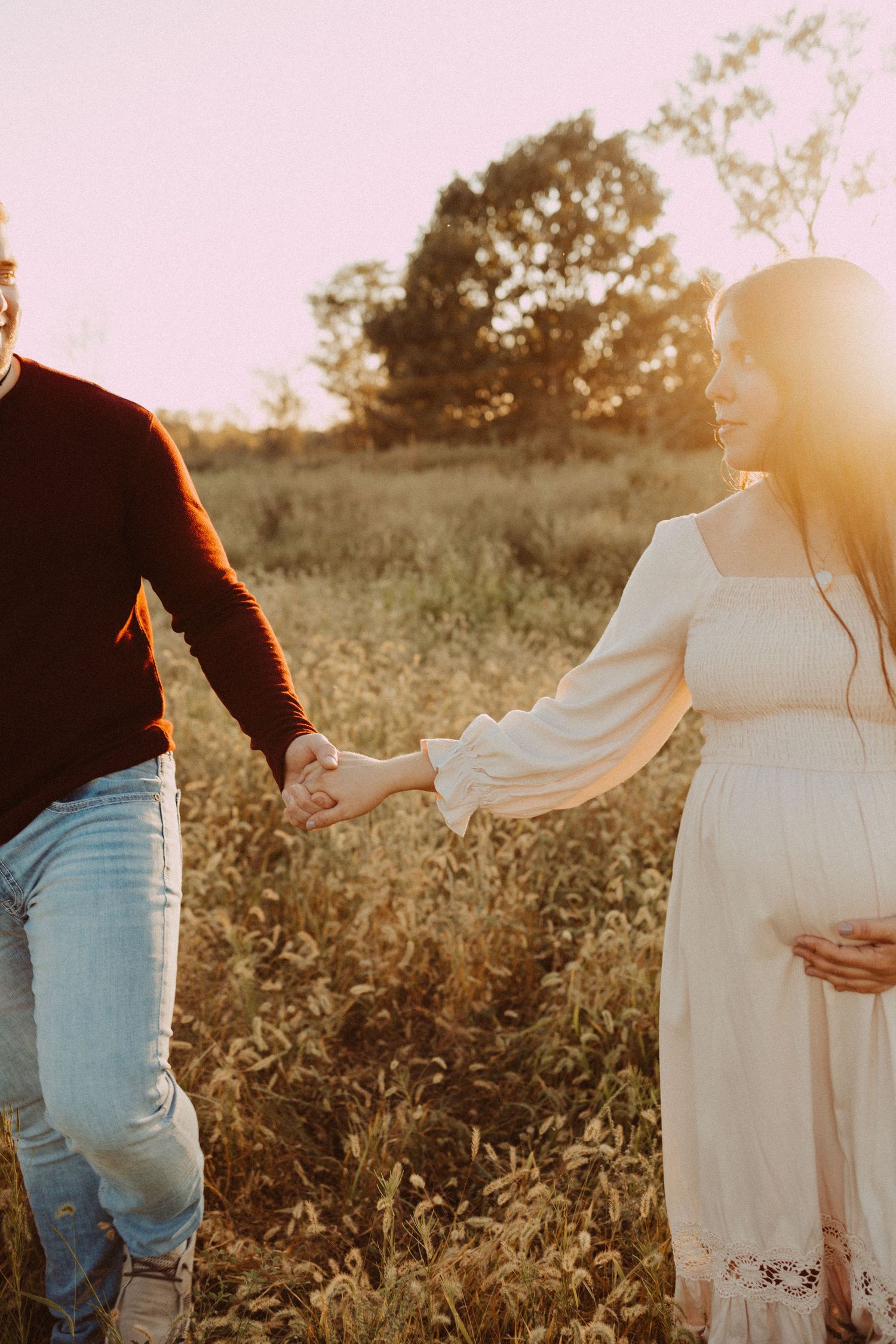 holding hands in a field maternity photography