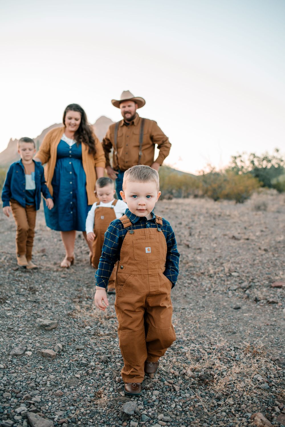 Desert photoshoot featuring family in matching brown Carhartt overalls and denim.