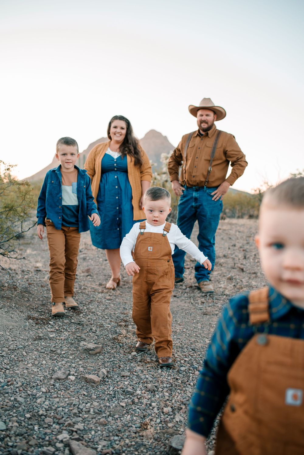 Casual desert family portraits with everyone wearing coordinated workwear outfits.