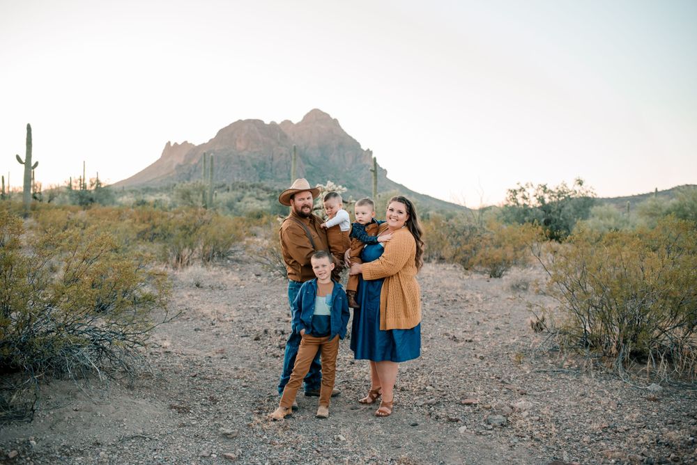Desert mountain landscape serves as backdrop for family photo in coordinated workwear.