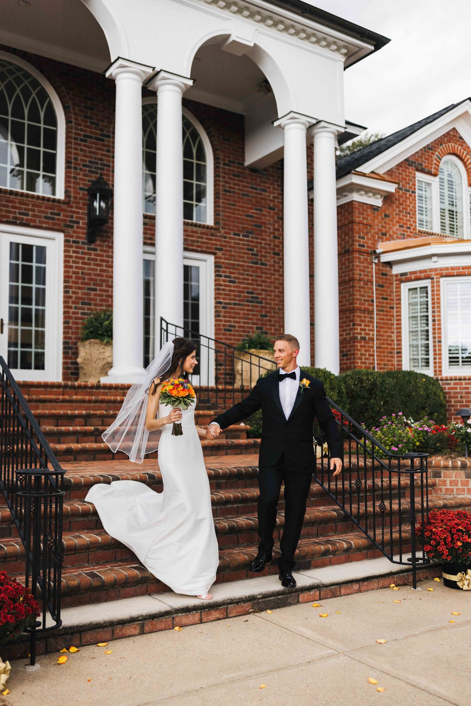 a Couple on their wedding day walking down the stairs in Raleigh NC