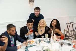 A group enjoying drinks and conversation at a formal dinner event.