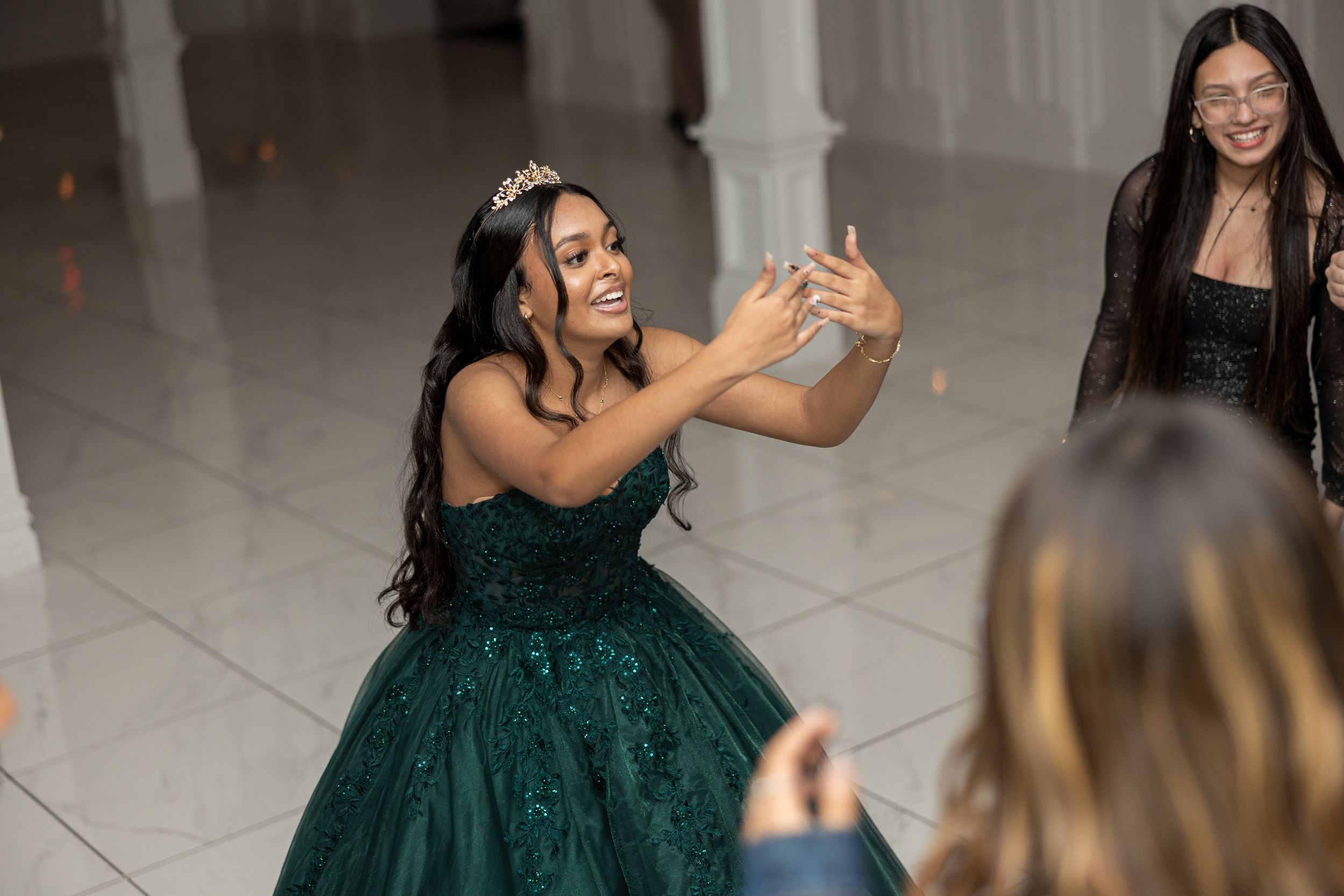 A celebratory moment captured as someone in a green gown dances at an event.
