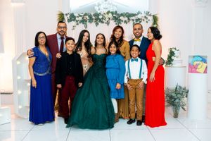 Large group celebration photo with guests in formal attire ranging from ball gowns to suits.