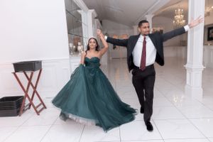 Dancing couple in formal attire twirl across white marble ballroom floor.
