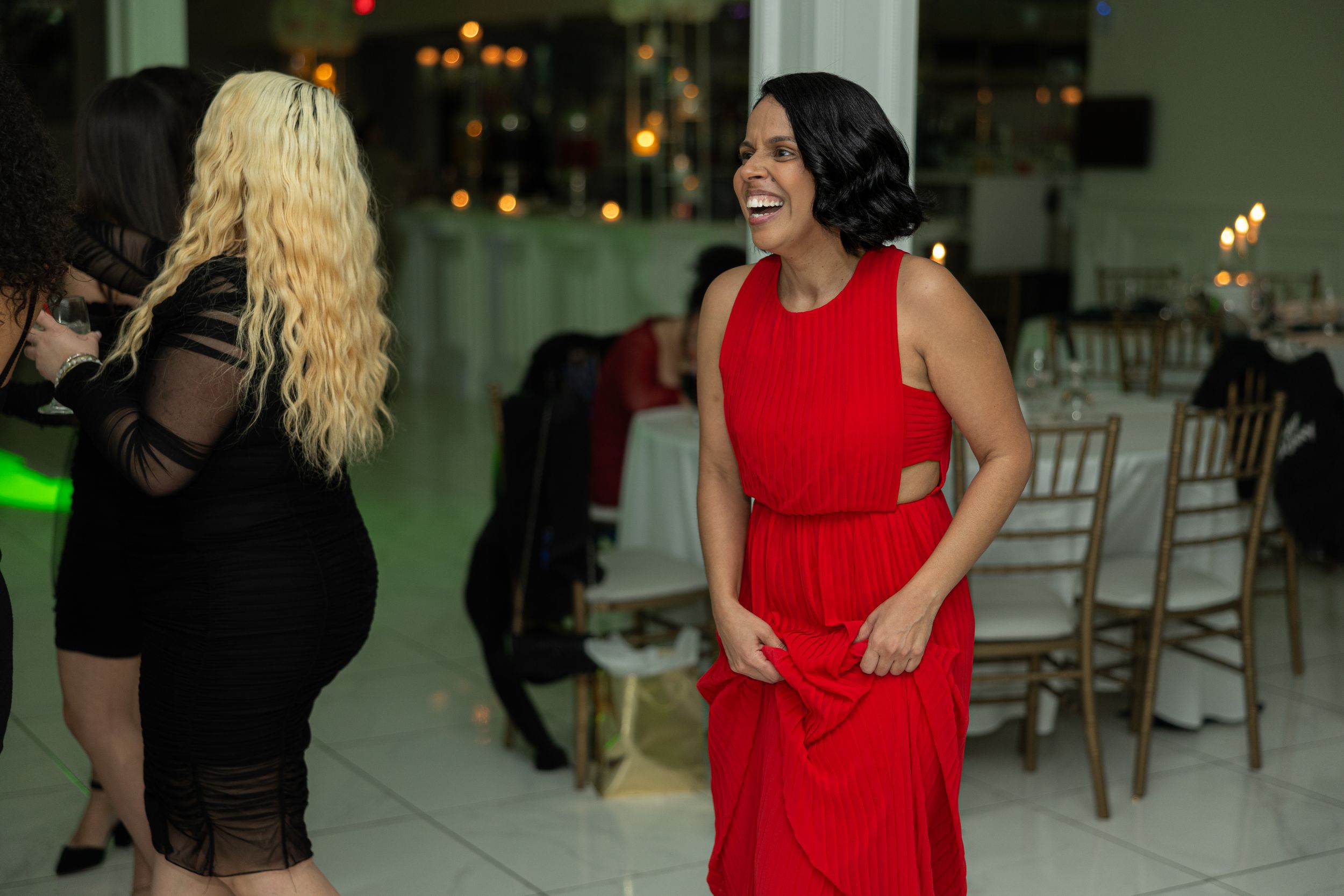 Two guests dancing and laughing together at an elegant indoor celebration.
