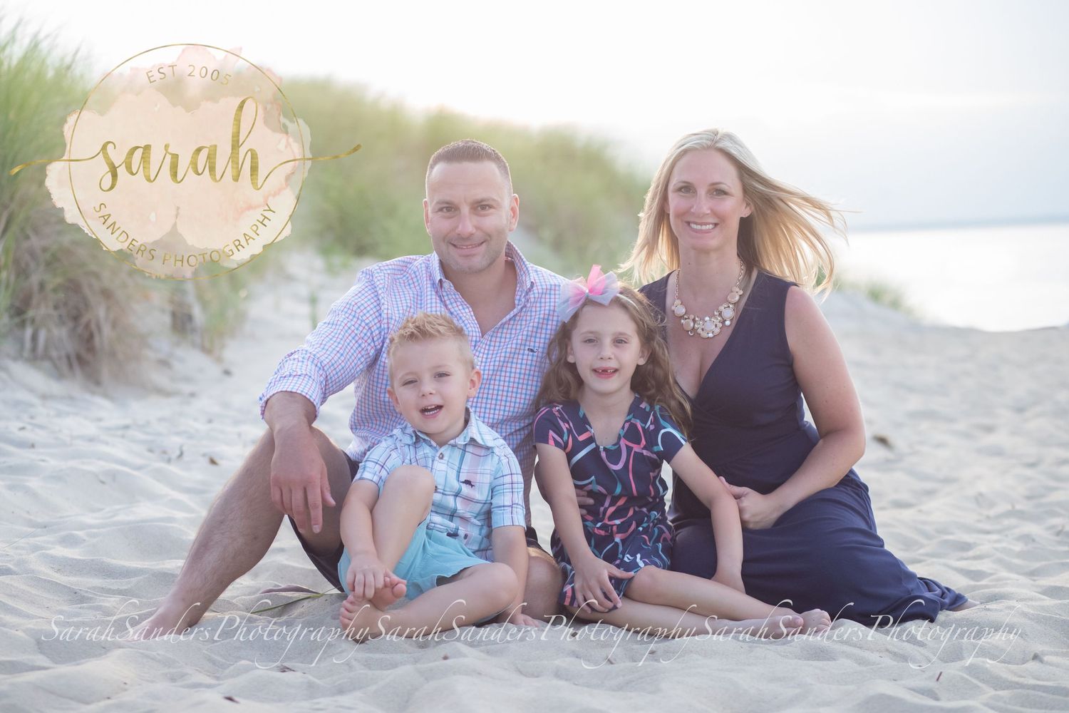 Family sitting in the sand at the beach
