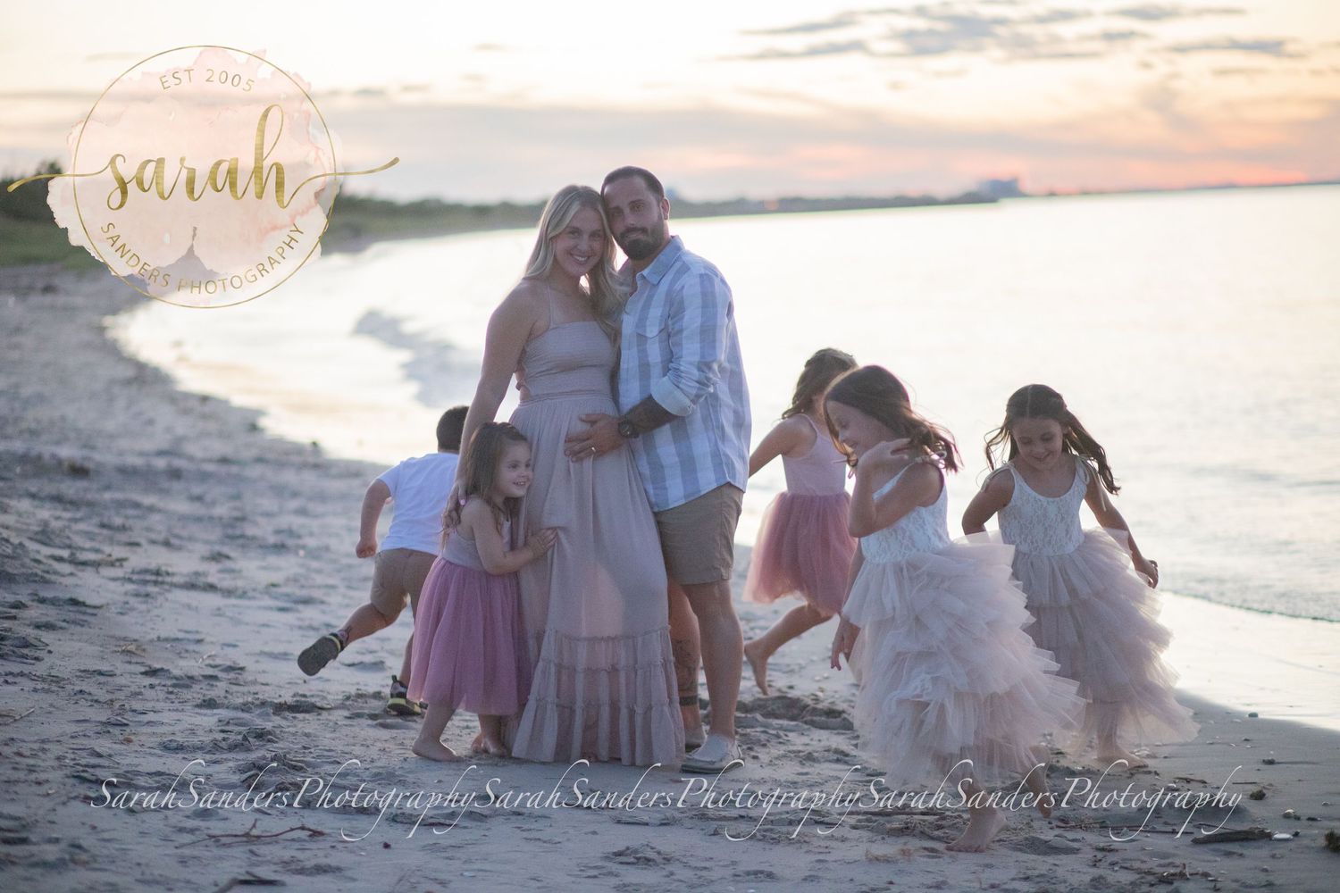Family portrait at the beach during sunset pregnancy announcement, kids running around