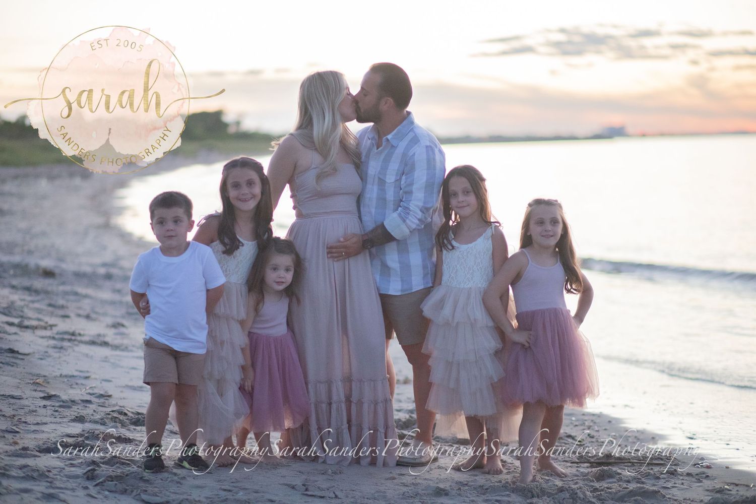Family portrait at the beach during sunset pregnancy announcement