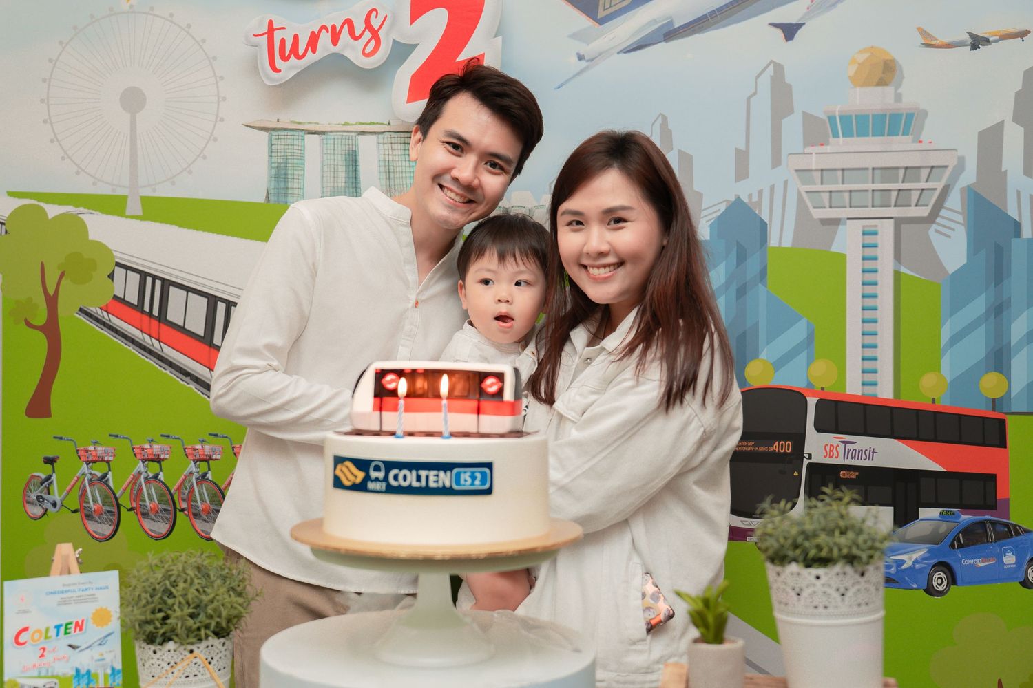 A birthday celebration with transportation-themed backdrop and custom cake.