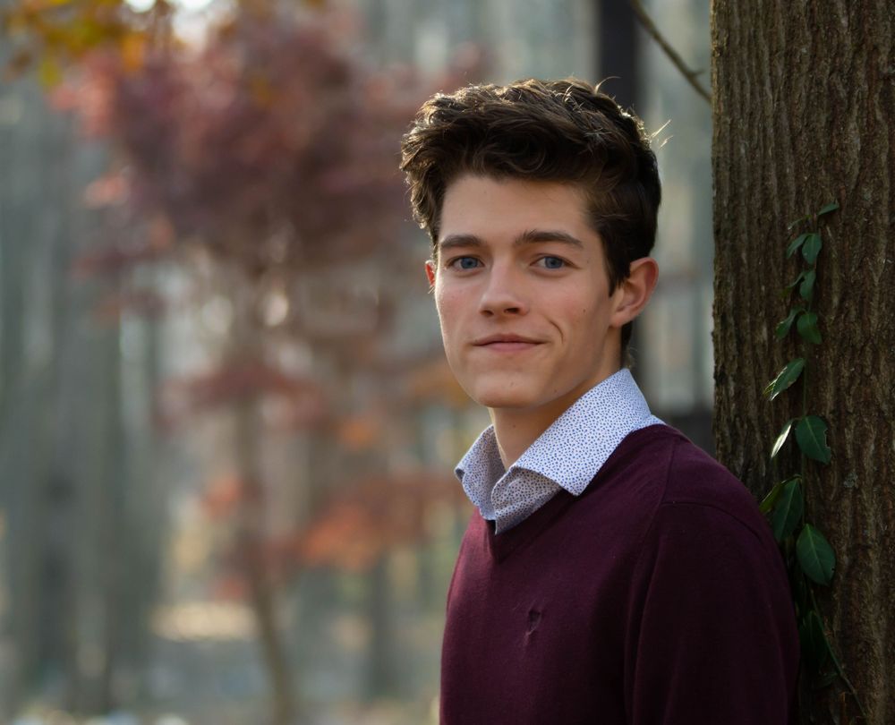 Portrait outdoors showing autumn foliage in background with soft bokeh effect. Senior Photography Batavia Cincinnati Ohio