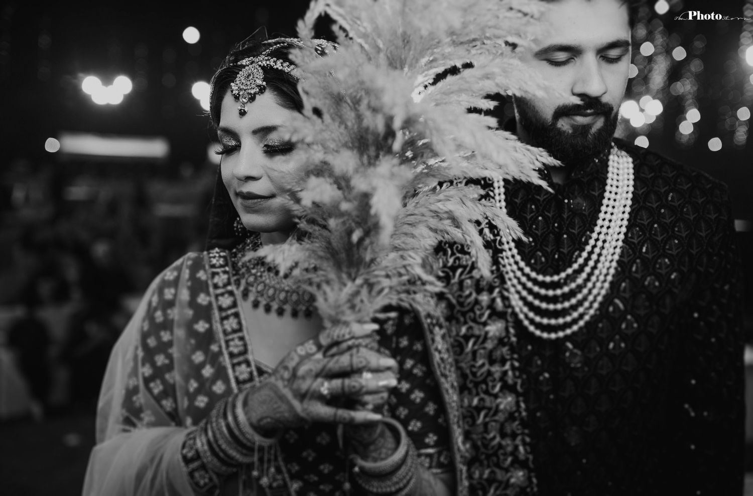 Black and white portrait showcasing intricate bridal jewelry and traditional Indian wedding attire.