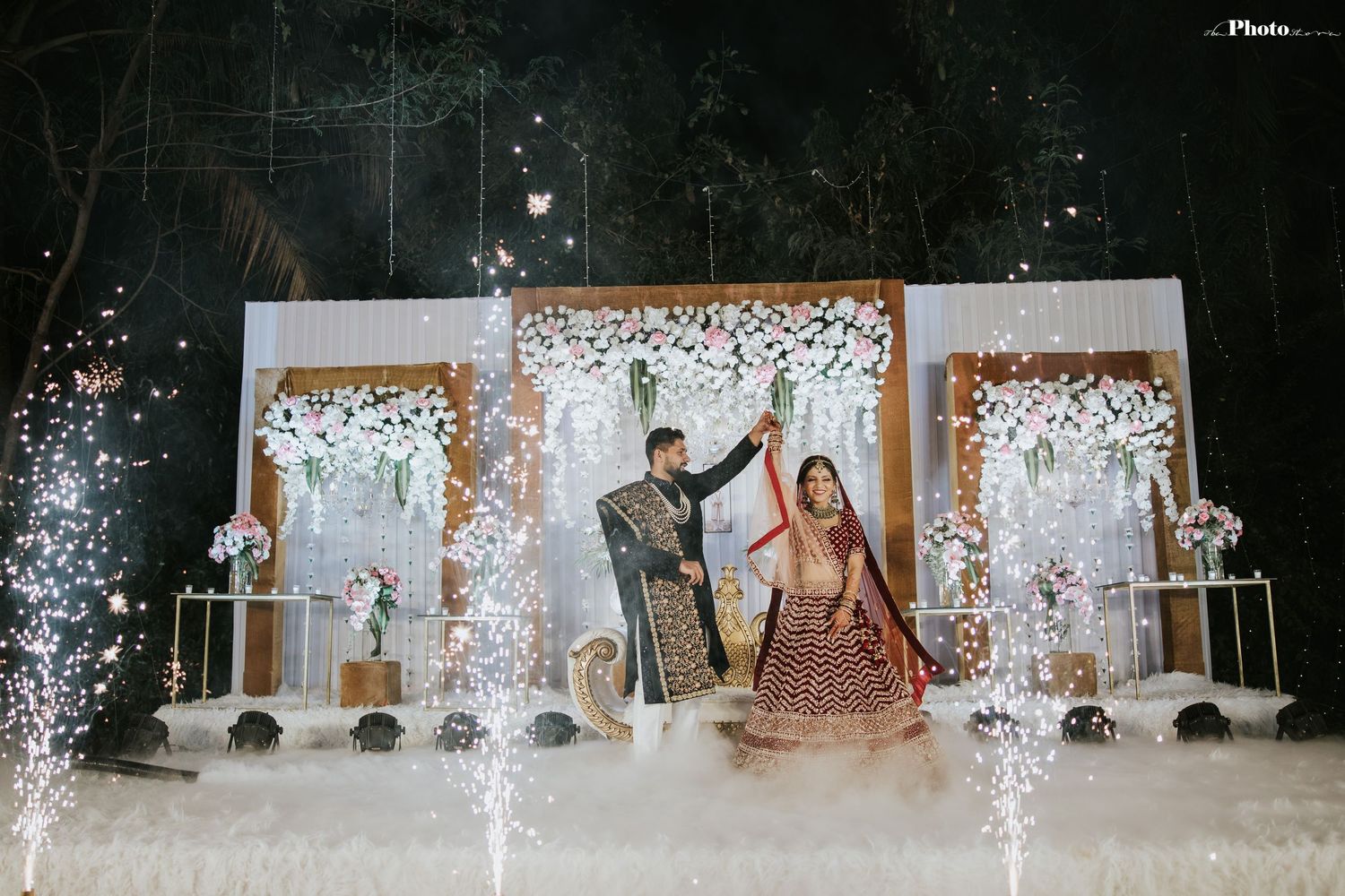A grand wedding finale with fountains of sparklers framing the decorated stage.
