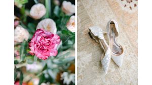 Pink carnation flower next to elegant white bridal shoes on textured surface.