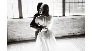 Black and white romantic dance moment captured in industrial loft space.