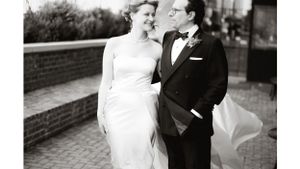 Elegant black and white wedding portrait of a couple in formal attire on brick pavers.