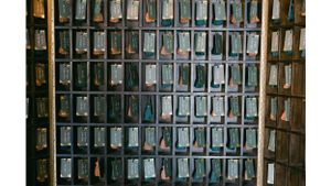A wall of post office mailboxes with numbered slots in an antique metal cabinet.