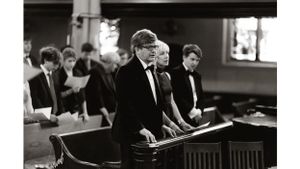 Musician playing piano at formal event in black and white photography.