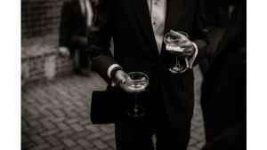 Two people in formal attire holding cocktail glasses during an elegant event.
