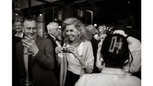 Group of guests enjoying drinks and laughing at an elegant party.
