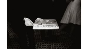A serving tray with ornate place settings on a textured floor.