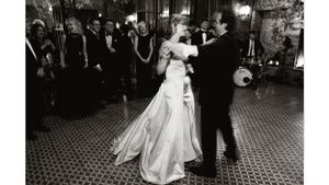 Black and white photo of newlyweds sharing their first dance on a tiled ballroom floor.