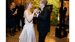 Wedding reception dance between guests on a patterned tile floor.