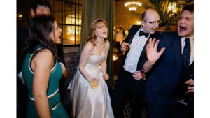Wedding guests share laughter and joy during an elegant evening reception celebration.