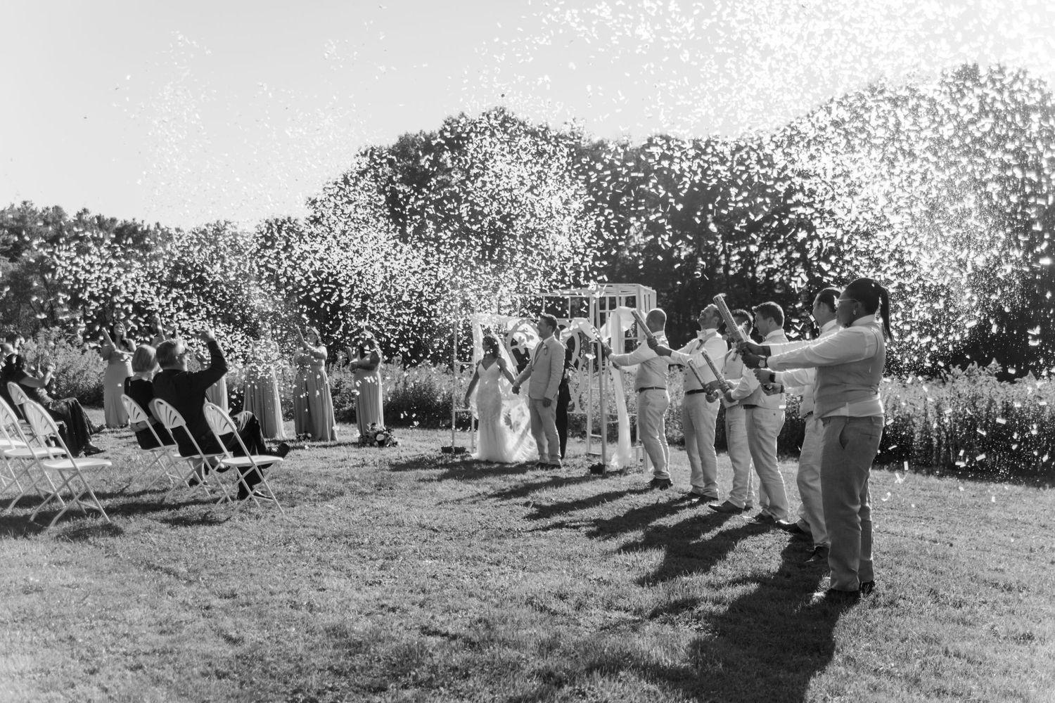 Wedding party strikes playful yoga poses on a grassy lawn during outdoor photo session.