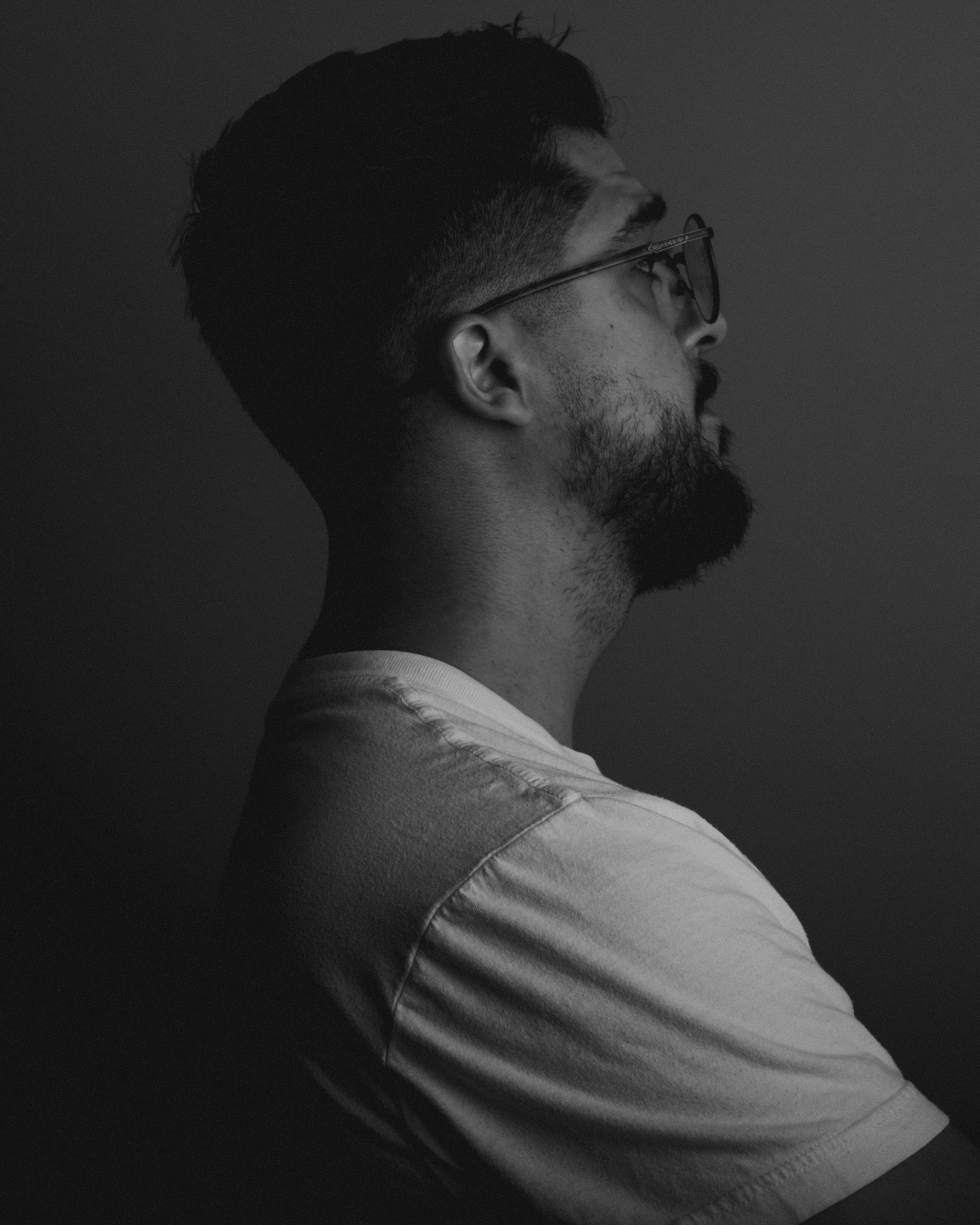 Dramatic black and white profile portrait of Juan C. Nava against dark background.