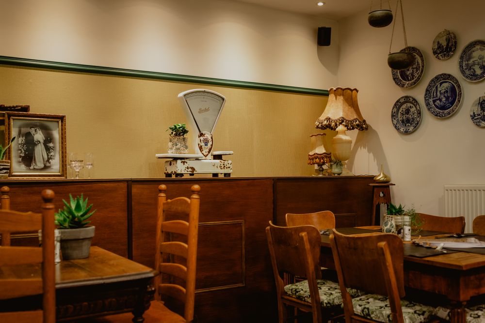 Cozy restaurant seating area with wooden chairs and decorative blue plates on wall.