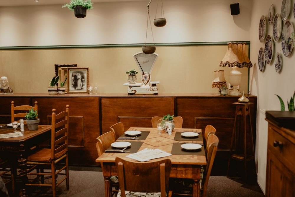 Cozy restaurant dining room with wooden furniture and wall decorations.