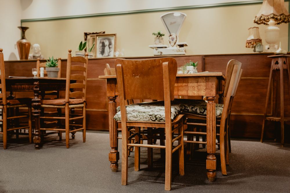 Empty restaurant interior with wooden chairs and tables in warm lighting.