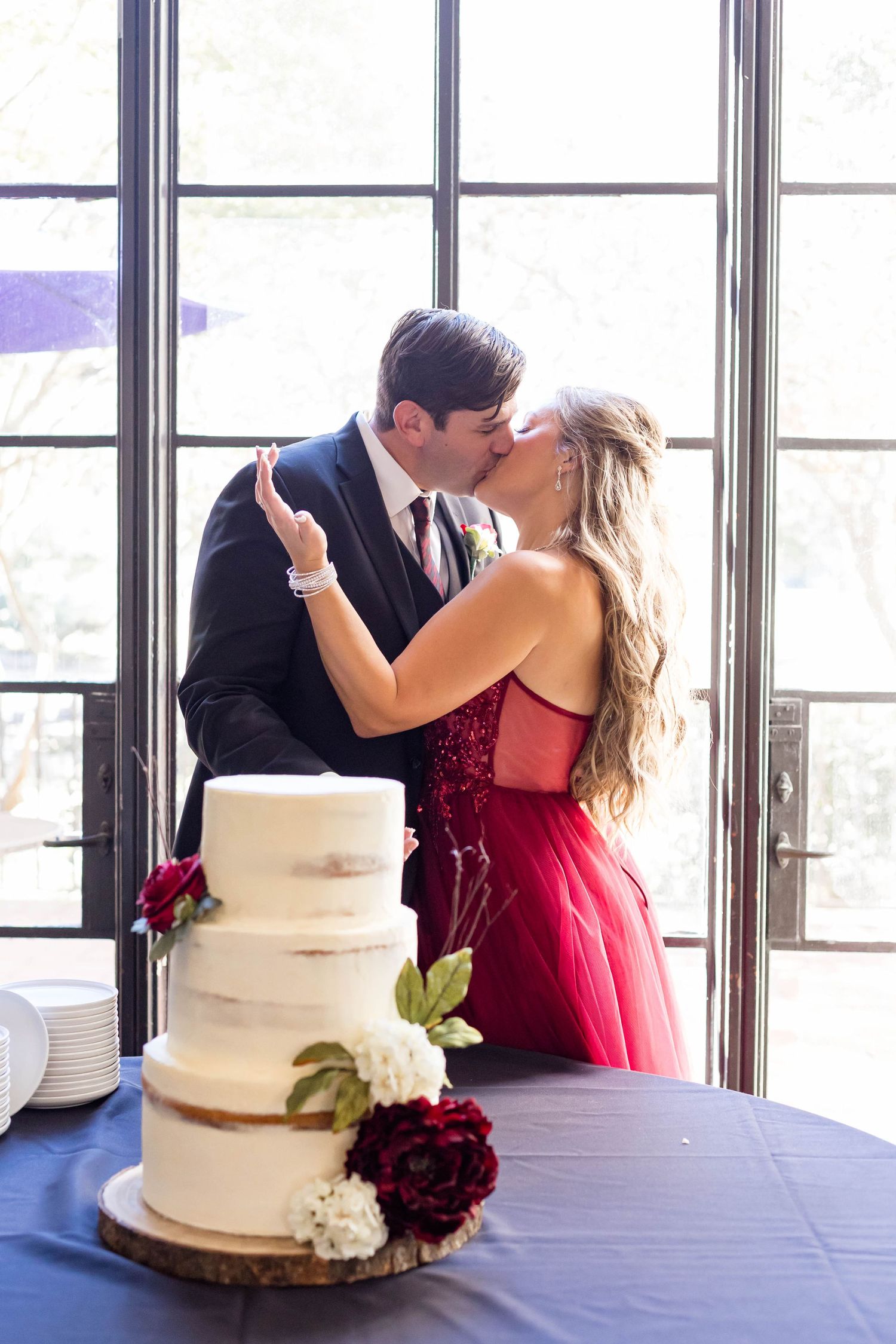 bride and groom kiss after eating cake