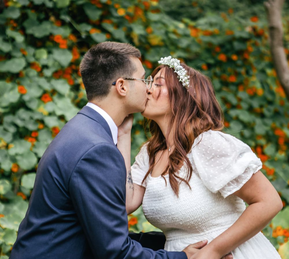 Romantic sequence of a couple kissing in a lush garden setting with orange blooms.