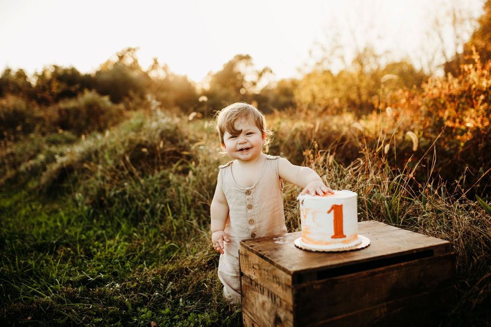 Outdoor autumn photoshoot with wooden crate and cake setup.