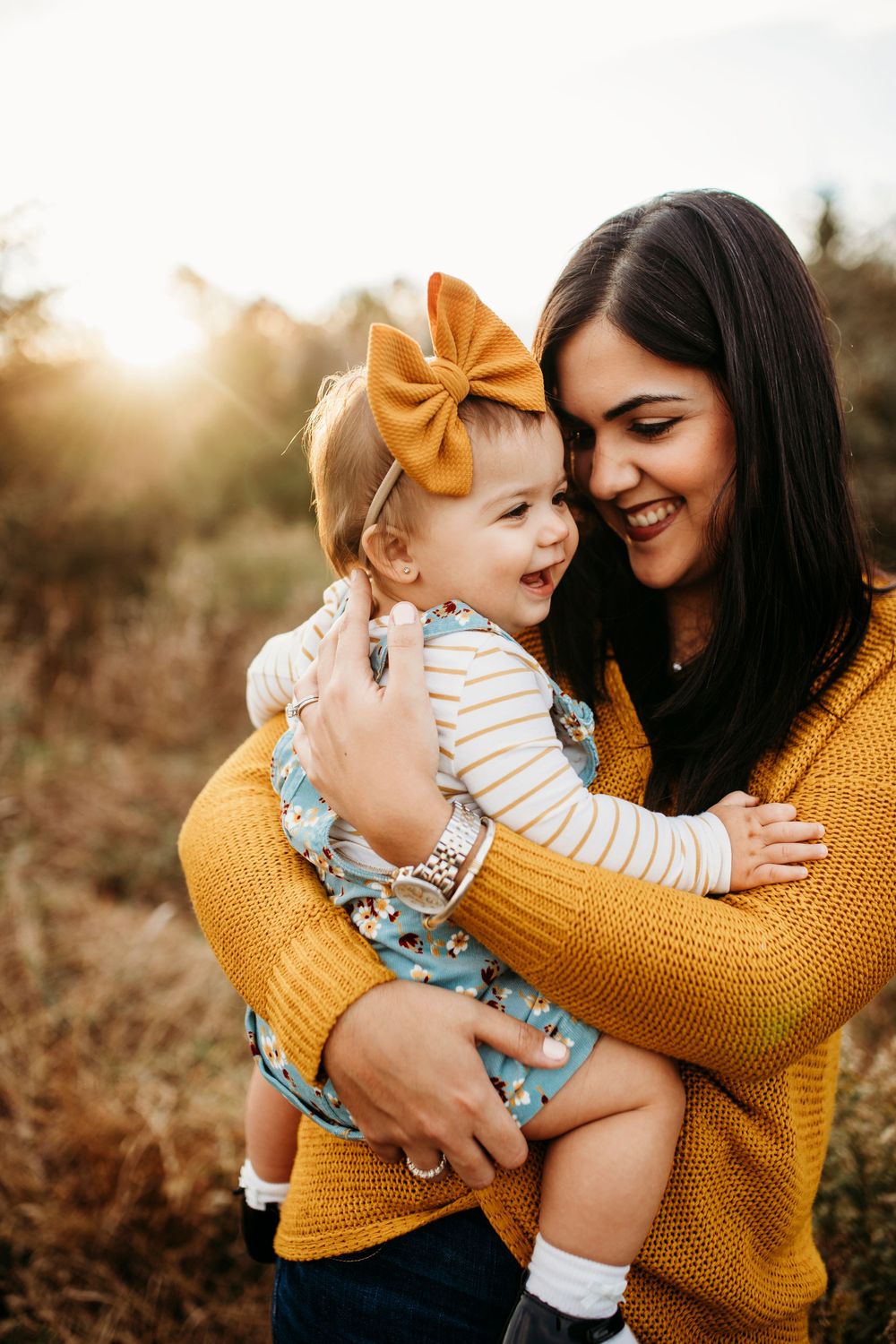 Candid moment captured in golden sunlight with yellow sweater and autumn foliage.