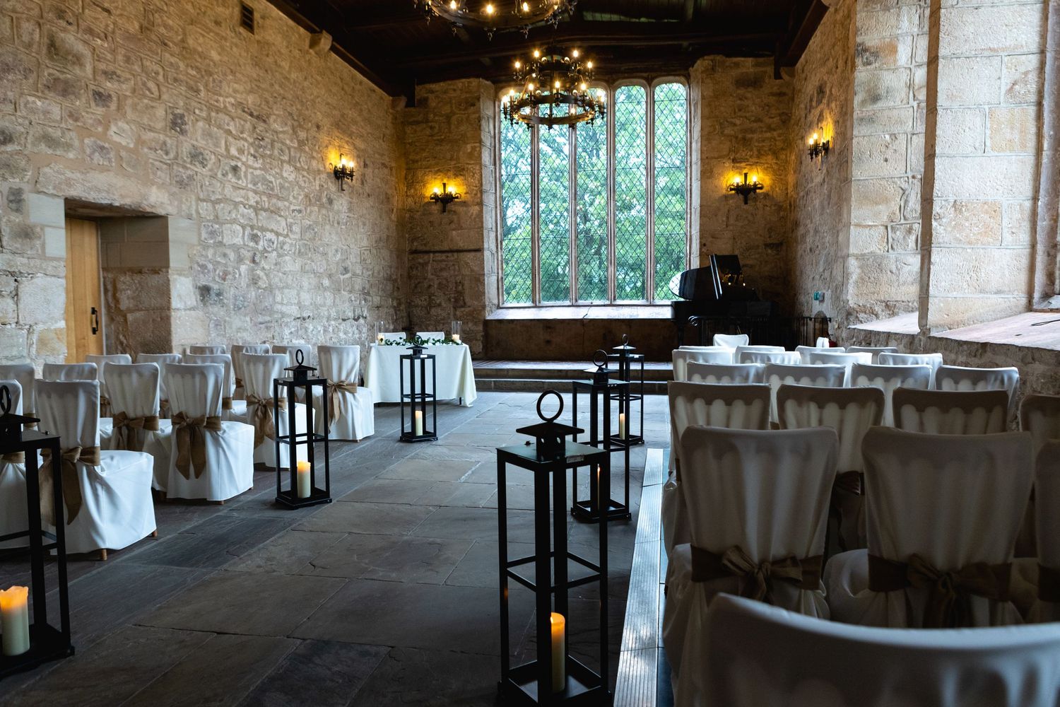 Rustic stone wedding venue interior with lantern decorations and elegant table settings.